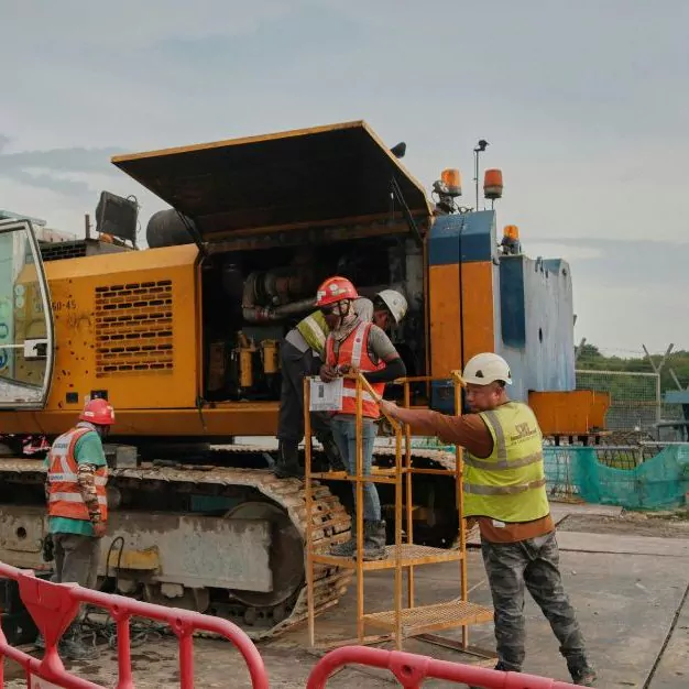 Workers interacting with mining equipment